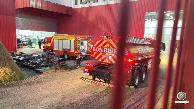 Bombeiros e funcionários de indústria combatem princípio de incêndio em máquina