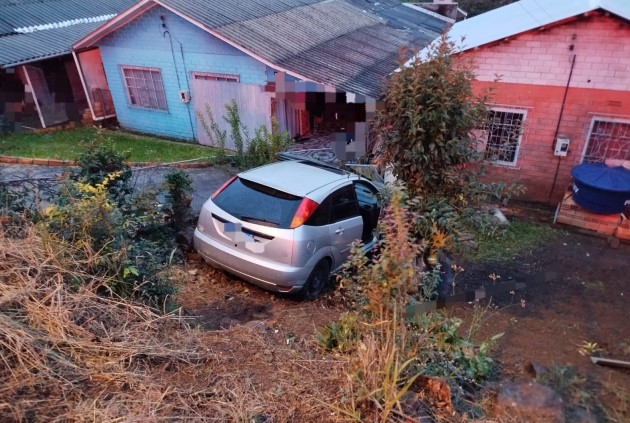 Veículo sai da pista, desce barranco e invade terreno de residência