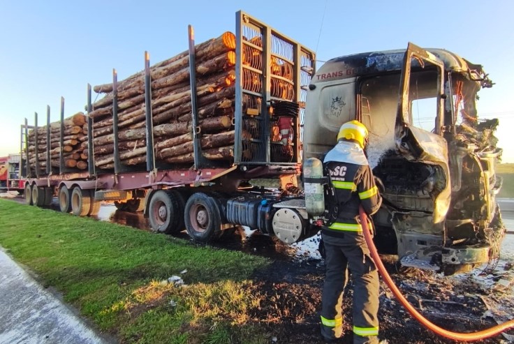 Caminhão carregado com madeira pega fogo na BR-282